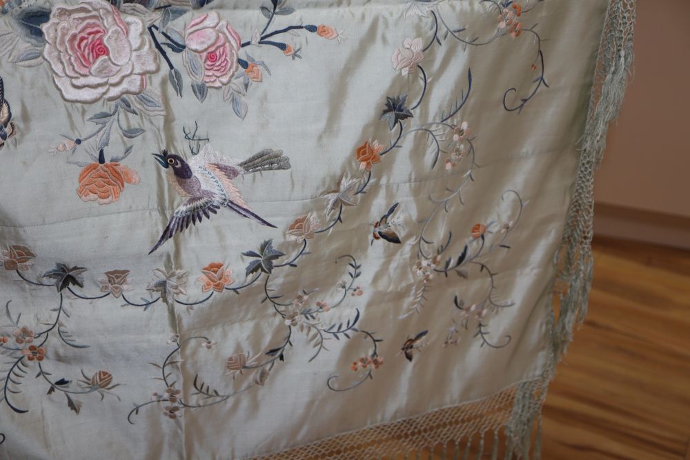 A late 19th century Chinese embroidered and fringed cover, decorated with flowers and butterflies on a pale turquoise background